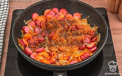 Добавьте в сковороду сосиски. Обжарьте все вместе еще 3 минуты. Посолите и поперчите по вкусу.