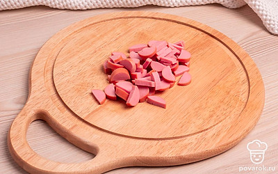 Нарежьте сосиску небольшими полукольцами. Натрите сыр на крупной терке.