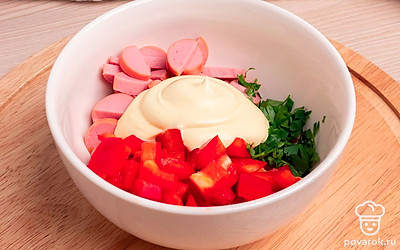 Добавьте и перемешайте в тарелке майонез, нарезанные петрушку, болгарский перец и сосиску. Оставьте небольшое количество рубленой петрушки для украшения.