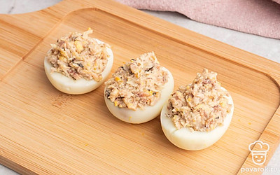 Полученную смесь выложите в готовые половинки яичного белка.