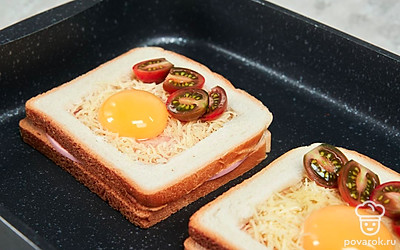 Приготовьте тост с яйцом. В каждый тост разбейте по яйцу, старайтесь не повредить желток. Рядом распределите по четыре половинки черри. Посолите, поставьте в духовку на 10-15 минут, желток не должен полностью затвердеть.