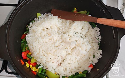 Как рис сварился, слейте лишнюю жидкость, смешайте рис с овощами.