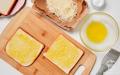 Подготовьте тосты. В миске смешайте растопленное сливочное масло, чеснок и соль. Этой смесью намажьте каждый ломтик.