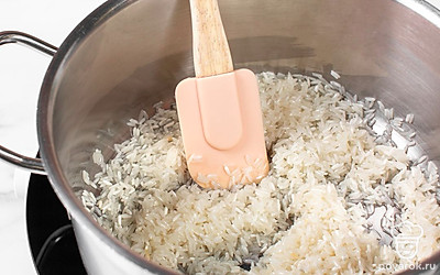 Разогрейте растительное масло в глубокой сковороде. Обжарьте на среднем огне рис в течение 3 минут, постоянно перемешивая.
