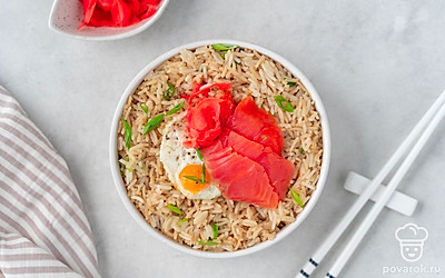 Украсьте блюдо с рисом маринованным имбирем, копченым лососем и жареным перепелиным яйцом.