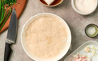 Сделайте тесто. Теплую воду соедините с сахаром и дрожжами. Оставьте на 15 минут. В отдельную миску всыпьте муку, соль и дрожжевую массу. Замесите мягкое тесто. Накройте кухонным полотенцем, уберите в тепло для подъема на 30-40 минут. После первого подъема вымесите тесто, оставьте еще на 10 минут.