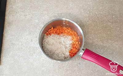 В сотейник выложите рис, морковь, соль и перец. Влейте половину воды и перемешайте. Накройте крышкой, тушите на небольшом огне 10 минут.