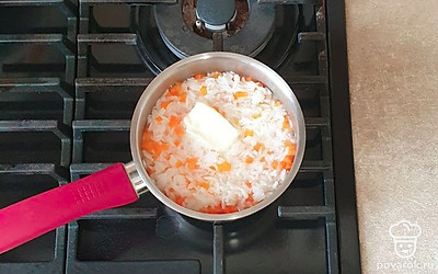 Через 10 минут влейте оставшуюся воду, добавьте сливочное масло, перемешайте. Готовьте еще 10 минут на маленьком огне под крышкой до полного испарения жидкости.