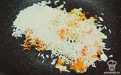 Затем в сковороду добавьте рис. Все обжаривайте пару минут. 