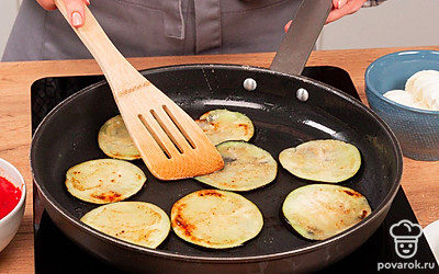 Разогрейте сковороду, влейте масло и пожарьте баклажаны с 2 сторон до золотистого цвета. Обжаренные баклажаны выложите на бумажное полотенце, чтобы оно впитало излишки масла.