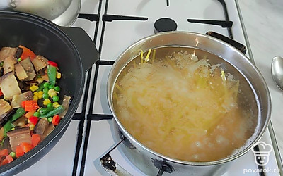 Лапшу отварите в подсоленной воде, откиньте на дуршлаг. Смешайте отваренную лапшу и овощи.