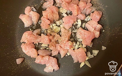 Нарежьте курицу на небольшие кусочки, добавьте в сковороду, посыпьте перцем. 