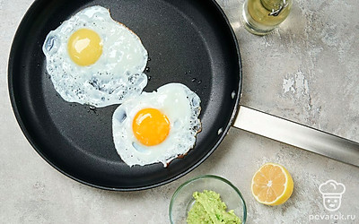 Подготовьте начинку. Мякоть авокадо разомните, сбрызните лимонным соком. Яйца обжарьте на сковороде, смазанной маслом.