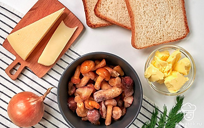 Разморозьте грибы и отожмите их от лишней жидкости. Репчатый лук очистите от шелухи и промойте, мелко нарежьте. Укроп вымойте и просушите, затем порубите. Натрите сыр на мелкой терке. Подготовьте нужную посуду: тарелку для подачи, нож и сковороду для готовки. Разогрейте духовку до 180 градусов.