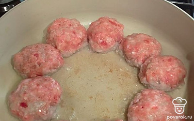 Влажными руками сформируйте фрикадельки. Выложите их в глубокий сотейник, оставляя середину пустой. Обжаривайте на растительном масле с обеих сторон.