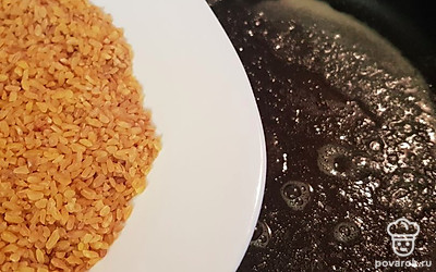 Растопите сливочное масло, добавьте 1 стакан булгура.