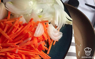 На сковороде обжарьте перьями нарезанный лук и соломкой нарезанную морковь.