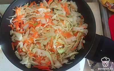 Выложите в сковороду лук, морковь и капусту, поставьте на медленный огонь.