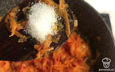 К томатной пасте обязательно добавить сахар. Все перемешать, добавить в капусту воду, накрыть крышкой и тушить на среднем огне.