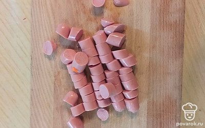 Добавить нашинкованную капусту и нарезанные сосиски. 