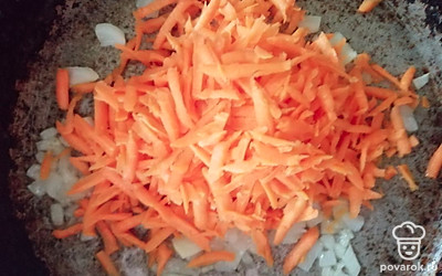 Далее к луку добавляем морковь, натертую на терке. Обжариваем морковь до мягкости. 