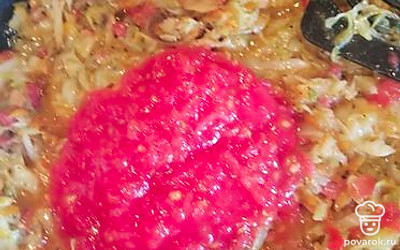 Когда капуста даст сок и станет мягкой, добавьте в сковороду помидор, предварительно очистив и натерев его на терке.