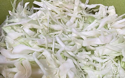 Вилок капусты очищаем от верхних листьев. Разрезаем на 2 половины и тонко шинкуем капусту специальным ножом. На сковороду наливаем масло и выкладываем капусту.