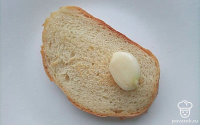 Для приготовления гренок обжаривайте ломтики батона на сухой раскаленной сковороде по 2-3 минуты с каждой стороны. Натрите получившиеся гренки чесноком.