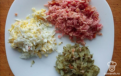 Натрите сосиски, яйцо и соленые огурцы на крупную терку, соедините все в глубокой миске и заправьте получившуюся начинку майонезом. Добавьте соль и перец по вкусу. Намажьте получившуюся начинку на гренки.