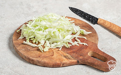 Капусту нашинкуйте мелкой соломкой и переложите в миску.