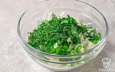 Переложите измельченную зелень в миску с капустой.