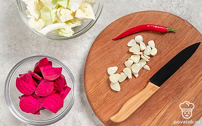 Разрежьте капусту на 4 полукруглые дольки. Чеснок нарежьте тонкими пластинками, свеклу — тонкими полукруглыми ломтиками, перец — колечками.