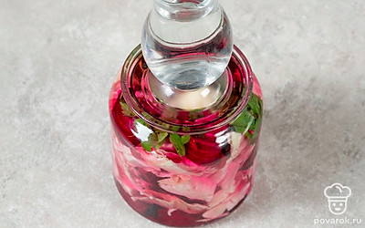 Придавите содержимое контейнера подходящей по размеру плоской тарелкой, плотно закройте крышкой и подержите 2-3 дня при комнатной температуре. Переместите маринованную капусту в холодильник или другое прохладное место. Оставьте там еще минимум на день.