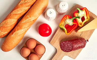 Подготовьте продукты для багета с сырокопченой колбасой. Овощи помойте. Перец, помидор, колбасу нарежьте мелкими кубиками. Сыр натрите на мелкой терке.