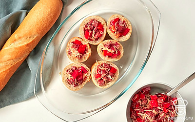 Приготовьте багет с сырокопченой колбасой. Багет нарежьте на кусочки шириной 5-6 см. Мякиш промните руками, чтобы из хлеба получились "стаканчики". Выложите до верха начинку. Запекайте в духовке при 180 градусах 15 минут.