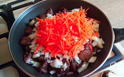 Добавьте к печени лук и морковь. Накройте сковороду крышкой и продолжайте тушить 15 минут на слабом огне.