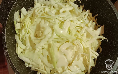 Кладем лавровый лист (по желанию). Добавляем нашинкованую капусту. Доливаем воду (примерно 1 стакан). Тушим, пока воды не станет совсем мало. В процессе перемешиваем.