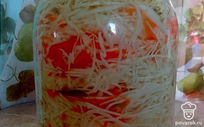 Переложите нарезанную капусту в трехлитровую банку, чередуя ее с нарезанной морковью. В середину положите лавровый лист и чеснок.