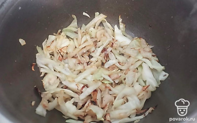 Выложите капусту в казан. Добавьте паприку и сушеную зелень. Перемешайте.