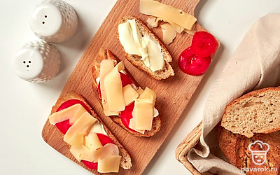 Приготовьте бутерброды из багета с голландским сыром. На кусочки ржаного багета выложите по два ломтика сыра, сверху разместите колечко помидора. Запеките в микроволновке на низкой мощности 2-3 минуты.