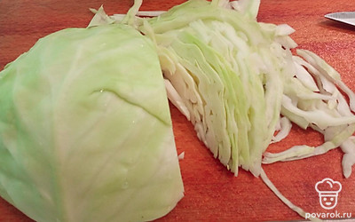 Нашинковать тонко капусту. У меня вилок примерно на 1 килограмм. Чем тоньше шинковать, тем нежнее она будет в готовом блюде. 