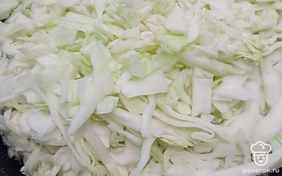 Выложить капусту на сухую сковороду, с горкой. Добавить воды примерно 100-150 миллилитров. Поставить на средний огонь. 