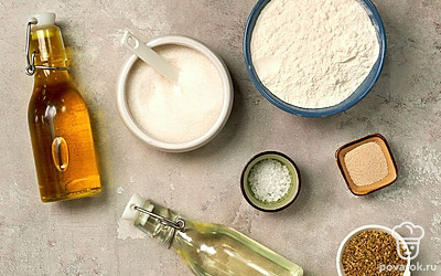 Просейте муку, воду подогрейте до температуры чуть выше комнатной. Смешайте в отдельной емкости сушеный орегано и оливковое масло. Подготовьте духовой шкаф, застелите противень пергаментной бумагой. Заварите чай с шиповником.