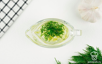 Приготовьте начинку для картофеля. Укроп и чеснок порубите мелко. Выложите в миску и смешайте с растительным маслом, солью и специями.