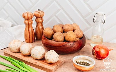 Картофель очистите, положите в кастрюлю, залейте холодной водой, посолите, дайте постоять 20 минут. Шампиньоны помойте и просушите бумажным полотенцем. Удалите верхний слой кожицы шляпки грибов, удалите все потемнения и обновите срез ножки гриба.