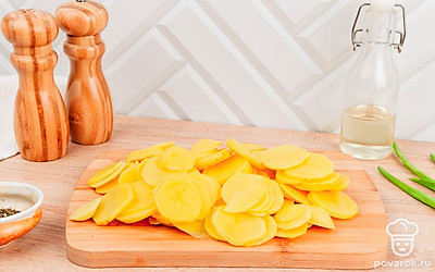 Картофель достаньте из воды, просушите и нарежьте тонкими кружочками.