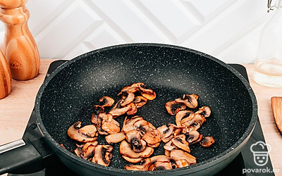 Разогрейте другую сковороду с кусочком сливочного масла и обжарьте грибы 5 минут.