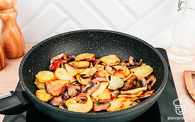 Грибы добавьте в сковороду к картофелю, посолите, поперчите, перемешайте и жарьте еще 3-5 минут. Блюдо готово.