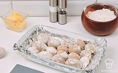 Застелите форму для запекания фольгой. Посыпьте каждую картофелину мукой и выложите в форму. Поставьте форму в разогретую духовку на 50 минут.