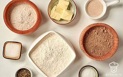 Просейте три вида муки и смешайте в миске, воду нагрейте до температуры немного выше комнатной. Растопите сливочное масло и смешайте его с базиликом. Застелите форму для выпечки специальной бумагой.